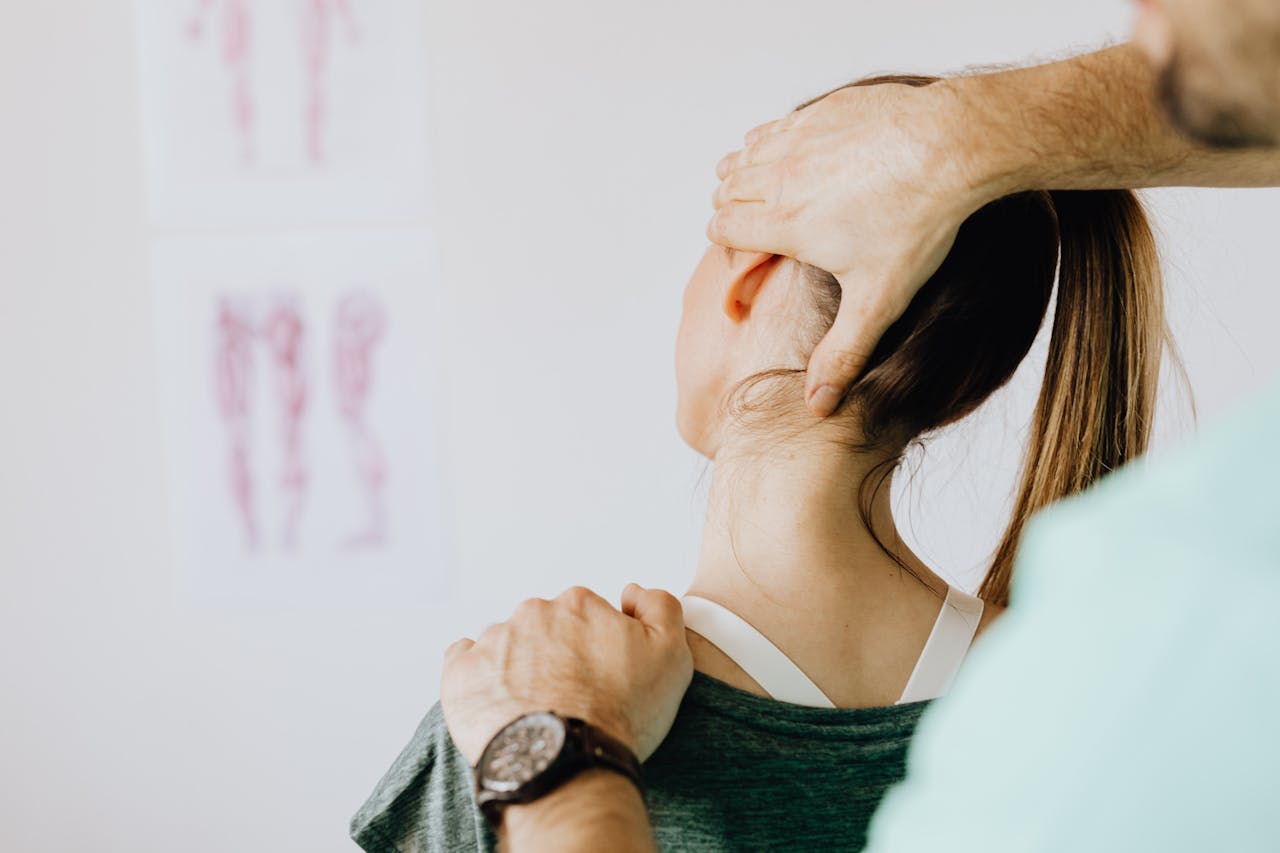 why-choose-us Back view of crop faceless bearded orthopedist in wristwatch checking up neck of anonymous lady while standing in front of wall with paper drawings representing body anatomy